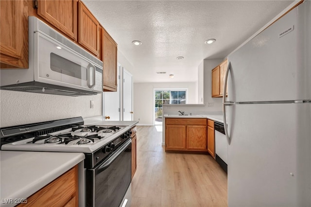 3448 Twilight Star Dr, Las Vegas, NV 89117 - kitchen with white appliances, light wood-style floors, brown cabinets, light countertops, and a textured ceiling