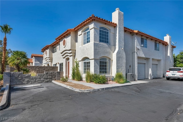 3448 Twilight Star Dr, Las Vegas, NV 89117 - mediterranean / spanish home featuring a chimney, a tile roof, stucco siding, and uncovered parking