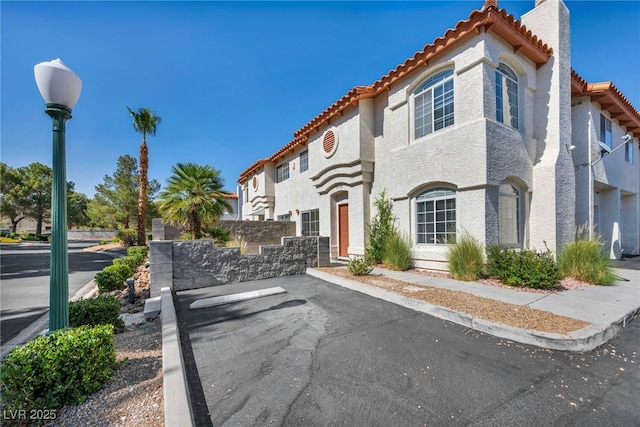 3448 Twilight Star Dr, Las Vegas, NV 89117 - mediterranean / spanish house featuring a tiled roof, uncovered parking, a chimney, and stucco siding