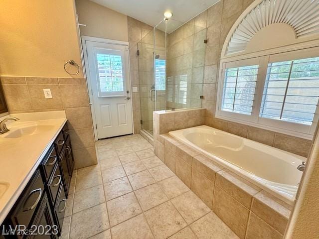 3197 Dusty Moon Ave, Henderson, NV 89052 - full bathroom featuring tile walls, double vanity, a bath, a shower stall, and healthy amount of natural light