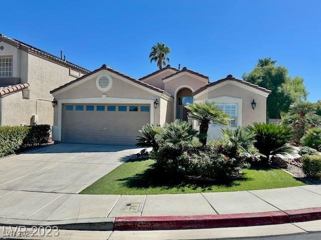 3197 Dusty Moon Ave, Henderson, NV 89052 - mediterranean / spanish home featuring an attached garage, driveway, and stucco siding