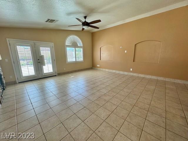 3197 Dusty Moon Ave, Henderson, NV 89052 - empty room with ceiling fan, light tile patterned floors, french doors, and a textured ceiling