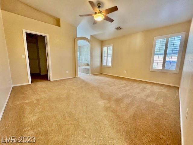 3197 Dusty Moon Ave, Henderson, NV 89052 - empty room with ceiling fan, lofted ceiling, carpet flooring, and arched walkways