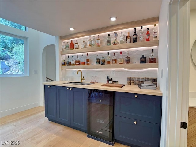 4651 Aspen Ave, Mount Charleston, NV 89124 - indoor wet bar featuring beverage cooler, decorative backsplash, light wood finished floors, recessed lighting, and arched walkways
