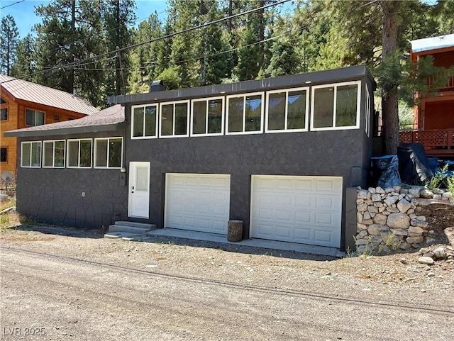 4651 Aspen Ave, Mount Charleston, NV 89124 - view of front of house with an attached garage, driveway, and stucco siding