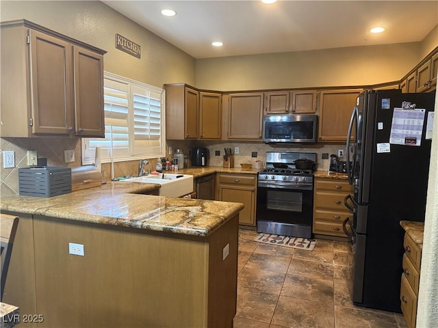 5315 Debut Ct, North Las Vegas, NV 89031 - kitchen with stainless steel appliances, a peninsula, decorative backsplash, light stone countertops, and recessed lighting