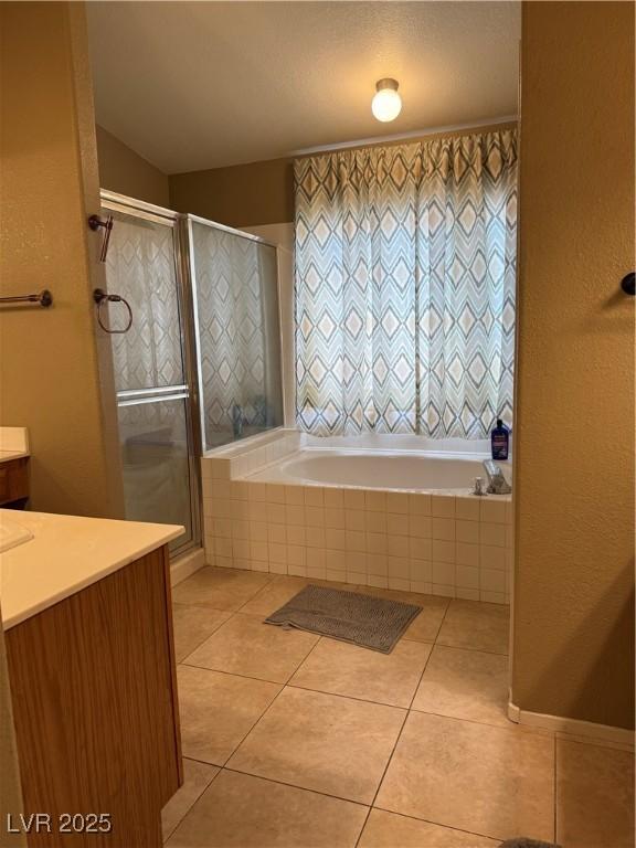5315 Debut Ct, North Las Vegas, NV 89031 - full bathroom featuring vanity, a garden tub, tile patterned flooring, and a shower stall