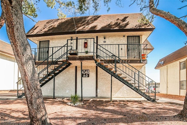 4348 Tara Ave Unit 2, Las Vegas, NV 89102 - view of front facade with stairway, stucco siding, and roof with shingles