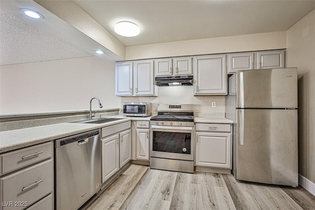 4348 Tara Ave Unit 2, Las Vegas, NV 89102 - kitchen featuring stainless steel appliances, ventilation hood, light countertops, light wood-type flooring, and recessed lighting