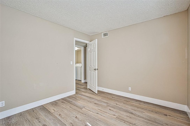 4348 Tara Ave Unit 2, Las Vegas, NV 89102 - empty room with light wood-style floors, washer / dryer, and a textured ceiling