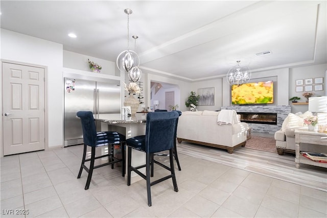 10183 Cascadia Creek St, Las Vegas, NV 89141 - dining area with a chandelier, light tile patterned floors, a raised ceiling, and a glass covered fireplace