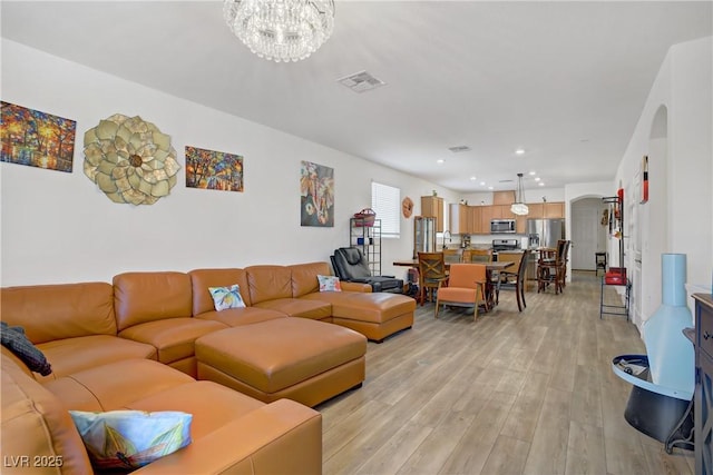 6324 Conlon St, North Las Vegas, NV 89081 - living area featuring arched walkways, light wood-style floors, a chandelier, and recessed lighting