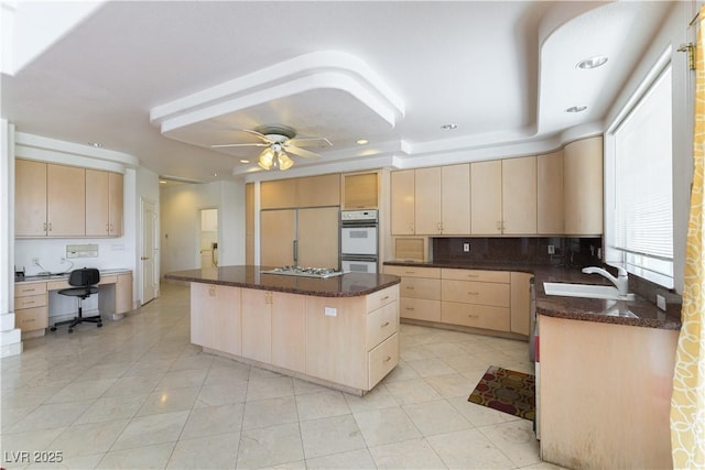 2019 Doral Ct, Henderson, NV 89074 - kitchen with light brown cabinetry, double oven, gas stovetop, paneled built in refrigerator, and a center island
