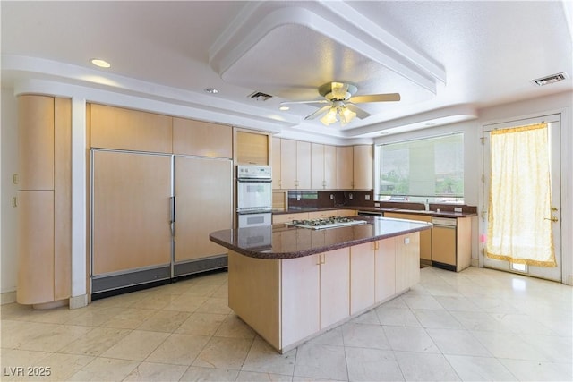 2019 Doral Ct, Henderson, NV 89074 - kitchen with white appliances, a kitchen island, a ceiling fan, a tray ceiling, and recessed lighting