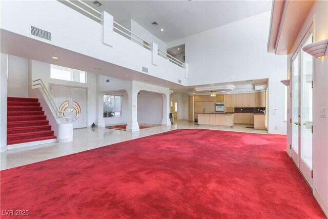 2019 Doral Ct, Henderson, NV 89074 - unfurnished living room with a high ceiling, arched walkways, stairs, ceiling fan, and recessed lighting