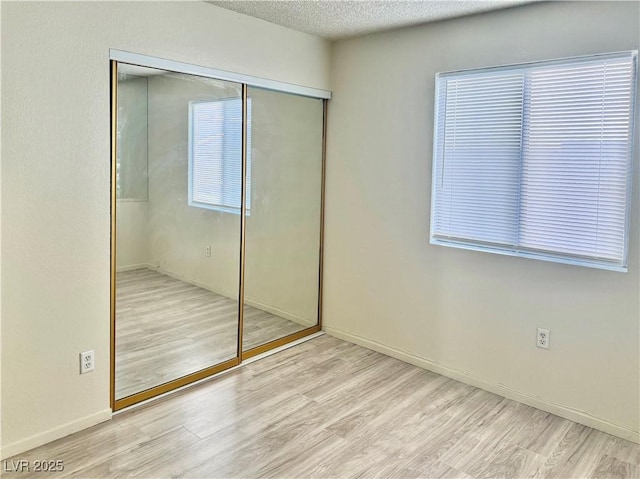 805 Rock Springs Dr Unit 101, Las Vegas, NV 89128 - unfurnished bedroom with a closet, wood finished floors, and a textured ceiling