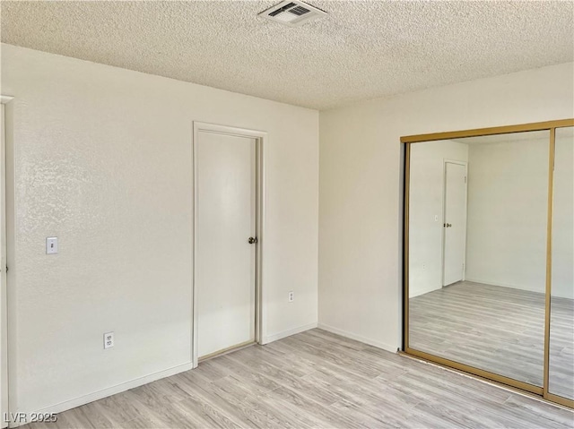 805 Rock Springs Dr Unit 101, Las Vegas, NV 89128 - unfurnished bedroom featuring light wood finished floors, a closet, and a textured ceiling