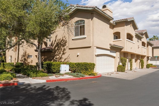 1609 Hills Of Red Dr Unit 104, Las Vegas, NV 89128 - view of building exterior with a garage and driveway