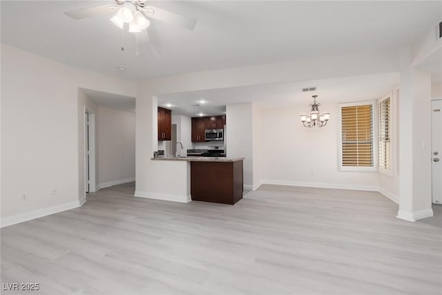 1609 Hills Of Red Dr Unit 104, Las Vegas, NV 89128 - kitchen with stainless steel microwave, open floor plan, light wood finished floors, a chandelier, and ceiling fan