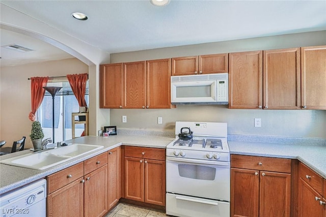 9068 Alluring Ave, Las Vegas, NV 89149 - kitchen featuring white appliances, light countertops, arched walkways, recessed lighting, and light tile patterned floors