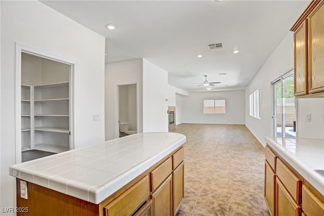 1208 Silver Bark Ave, North Las Vegas, NV 89081 - kitchen with tile counters, a ceiling fan, recessed lighting, open floor plan, and a center island