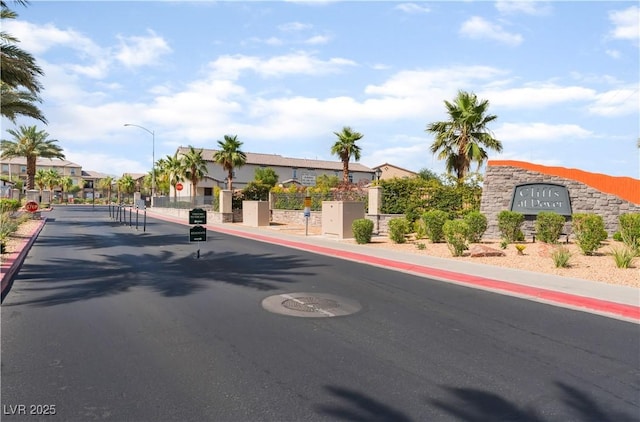 4588 Dover Straight St, Las Vegas, NV 89115 - view of asphalt street with traffic signs, street lights, a residential view, curbs, and a gate
