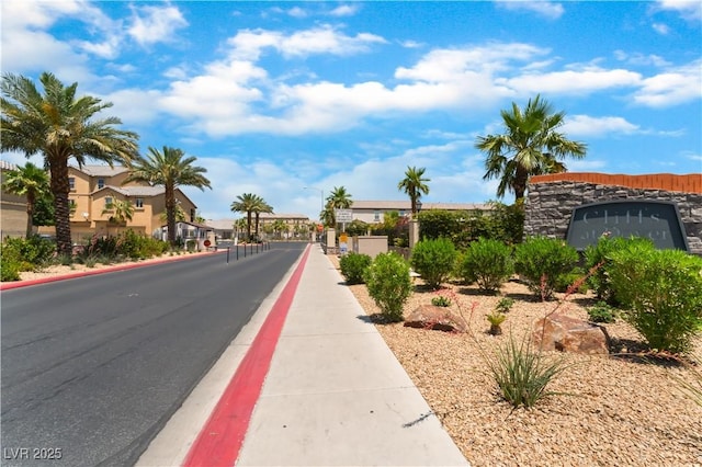 4588 Dover Straight St, Las Vegas, NV 89115 - view of asphalt road featuring street lights, sidewalks, curbs, and a gated entry