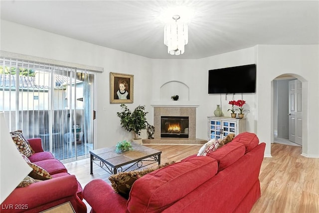 1713 Sky Of Red Dr Unit 201, Las Vegas, NV 89128 - living room with arched walkways, a chandelier, light wood-type flooring, and a fireplace