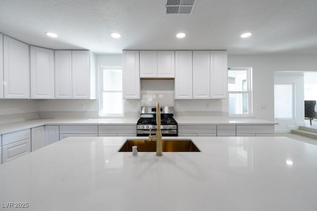 714 Lacy Ln, Las Vegas, NV 89107 - kitchen featuring gas stove, healthy amount of natural light, light countertops, recessed lighting, and a textured ceiling