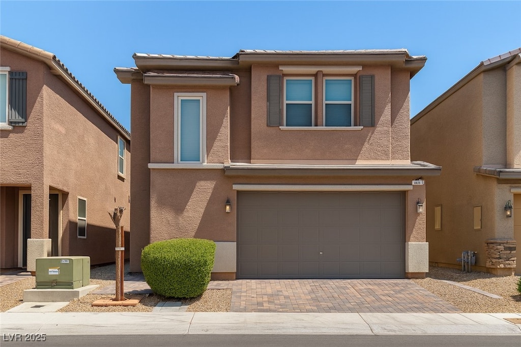 5355 Bennett Spring Ln, Las Vegas, NV 89122 - view of front of property featuring a garage, decorative driveway, stucco siding, and a tiled roof