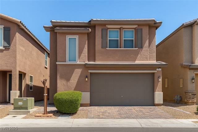 5355 Bennett Spring Ln, Las Vegas, NV 89122 - view of front of property featuring a garage, decorative driveway, stucco siding, and a tiled roof