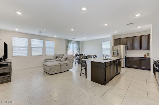 4133 Golden Fleece Ave, Las Vegas, NV 89141 - kitchen featuring appliances with stainless steel finishes, a breakfast bar, open floor plan, dark brown cabinetry, and light countertops