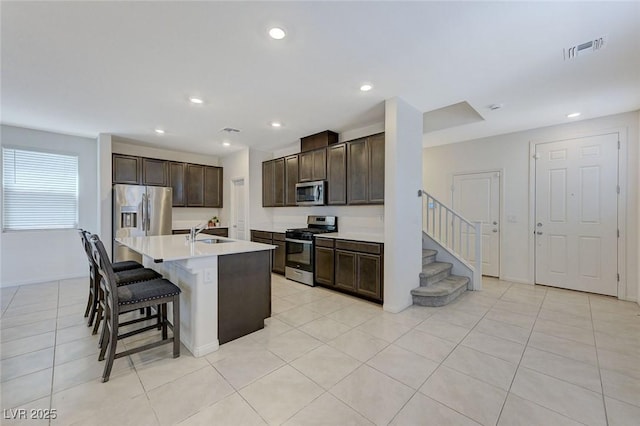 4133 Golden Fleece Ave, Las Vegas, NV 89141 - kitchen featuring stainless steel appliances, dark brown cabinets, a kitchen breakfast bar, an island with sink, and recessed lighting