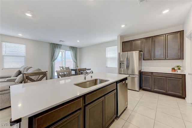 4133 Golden Fleece Ave, Las Vegas, NV 89141 - kitchen with appliances with stainless steel finishes, open floor plan, light countertops, light tile patterned floors, and dark brown cabinets