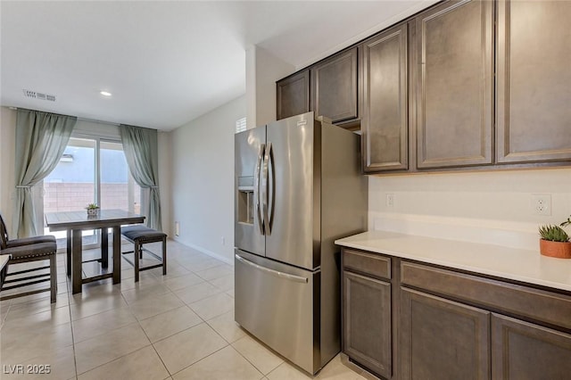 4133 Golden Fleece Ave, Las Vegas, NV 89141 - kitchen with stainless steel refrigerator with ice dispenser, light countertops, dark brown cabinets, light tile patterned floors, and recessed lighting