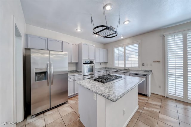 208 Glendon St, Henderson, NV 89074 - kitchen with appliances with stainless steel finishes, a kitchen island, recessed lighting, light tile patterned flooring, and light stone countertops