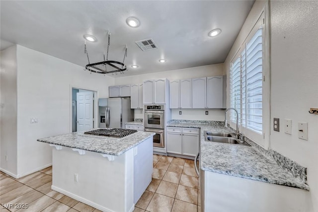 208 Glendon St, Henderson, NV 89074 - kitchen featuring a kitchen island, appliances with stainless steel finishes, light tile patterned floors, light stone countertops, and recessed lighting