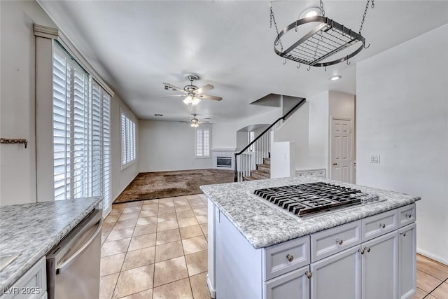 208 Glendon St, Henderson, NV 89074 - kitchen featuring a ceiling fan, appliances with stainless steel finishes, light tile patterned floors, white cabinetry, and a center island