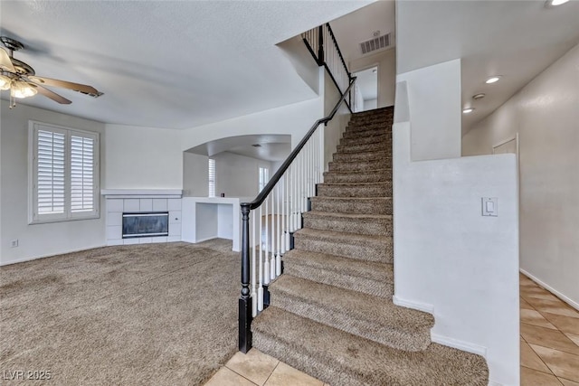 208 Glendon St, Henderson, NV 89074 - stairs featuring tile patterned flooring, a ceiling fan, a fireplace, arched walkways, and recessed lighting