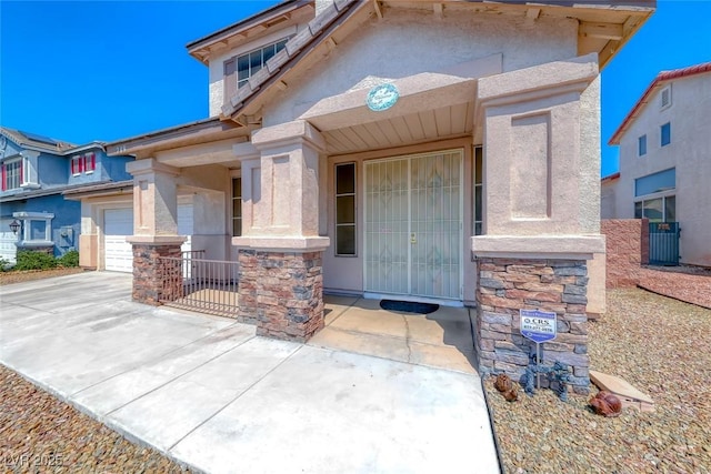 208 Glendon St, Henderson, NV 89074 - doorway to property featuring stucco siding, a garage, driveway, and stone siding