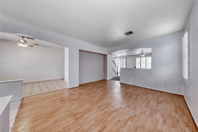 208 Glendon St, Henderson, NV 89074 - unfurnished living room featuring a ceiling fan, stairway, wood finished floors, and arched walkways