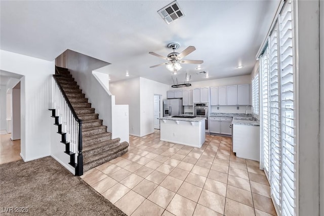 208 Glendon St, Henderson, NV 89074 - kitchen with a kitchen island, a ceiling fan, stainless steel appliances, white cabinetry, and open floor plan