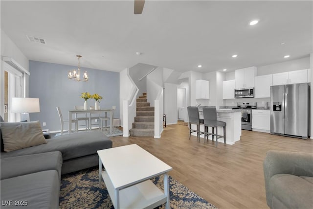 4650 Blaise Ave Unit 102, North Las Vegas, NV 89084 - living area with a chandelier, recessed lighting, stairs, and light wood-style flooring