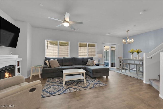 4650 Blaise Ave Unit 102, North Las Vegas, NV 89084 - living room with a chandelier, healthy amount of natural light, a warm lit fireplace, and stairway