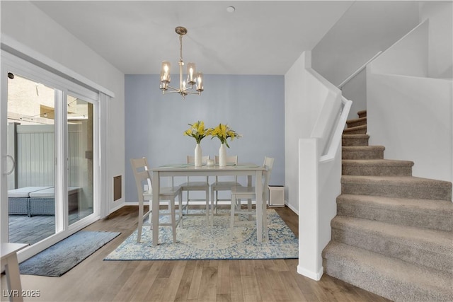 4650 Blaise Ave Unit 102, North Las Vegas, NV 89084 - dining area featuring stairway, wood finished floors, and a chandelier