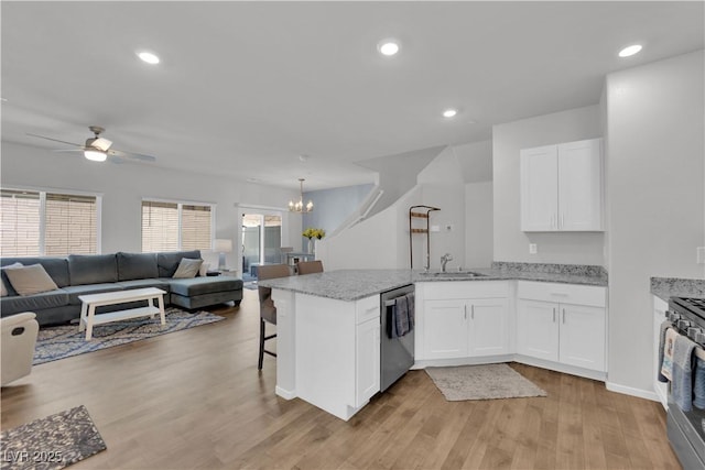 4650 Blaise Ave Unit 102, North Las Vegas, NV 89084 - kitchen with stainless steel dishwasher, open floor plan, a peninsula, a ceiling fan, and white cabinets