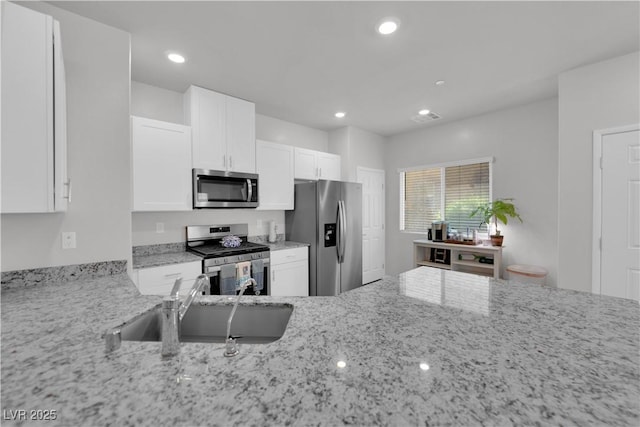 4650 Blaise Ave Unit 102, North Las Vegas, NV 89084 - kitchen featuring appliances with stainless steel finishes, light stone counters, white cabinets, and recessed lighting