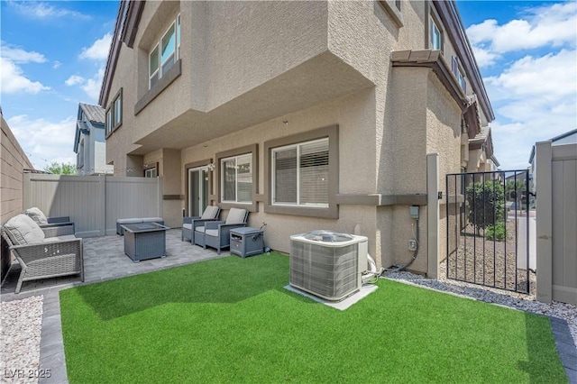 4650 Blaise Ave Unit 102, North Las Vegas, NV 89084 - back of house featuring stucco siding, a patio area, a fenced backyard, a gate, and an outdoor living space with a fire pit