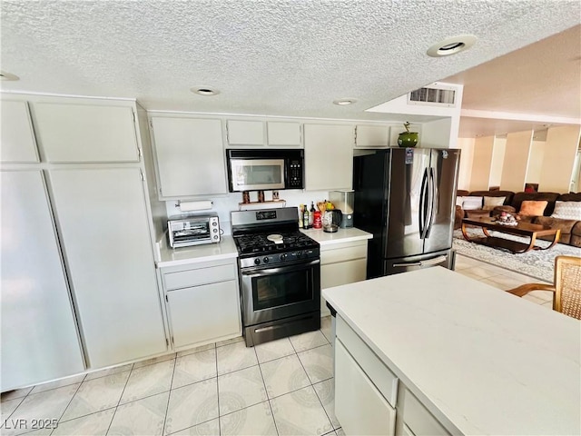 421 Courtney Ln, Las Vegas, NV 89107 - kitchen with appliances with stainless steel finishes, light countertops, a textured ceiling, light tile patterned flooring, and recessed lighting