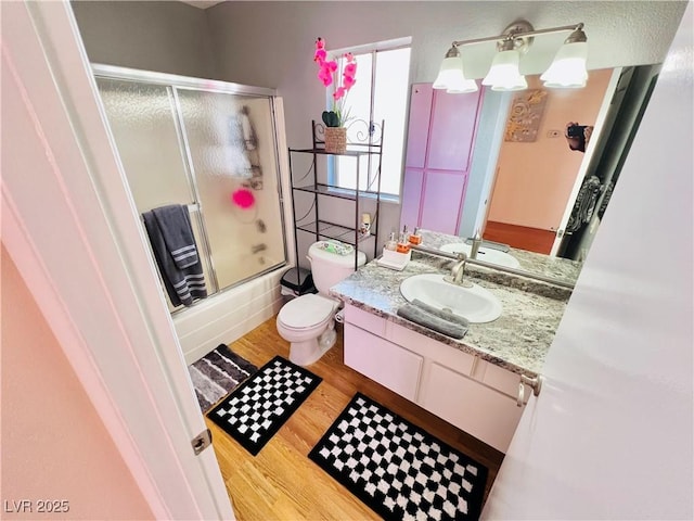 421 Courtney Ln, Las Vegas, NV 89107 - full bathroom with wood finished floors, vanity, and bath / shower combo with glass door